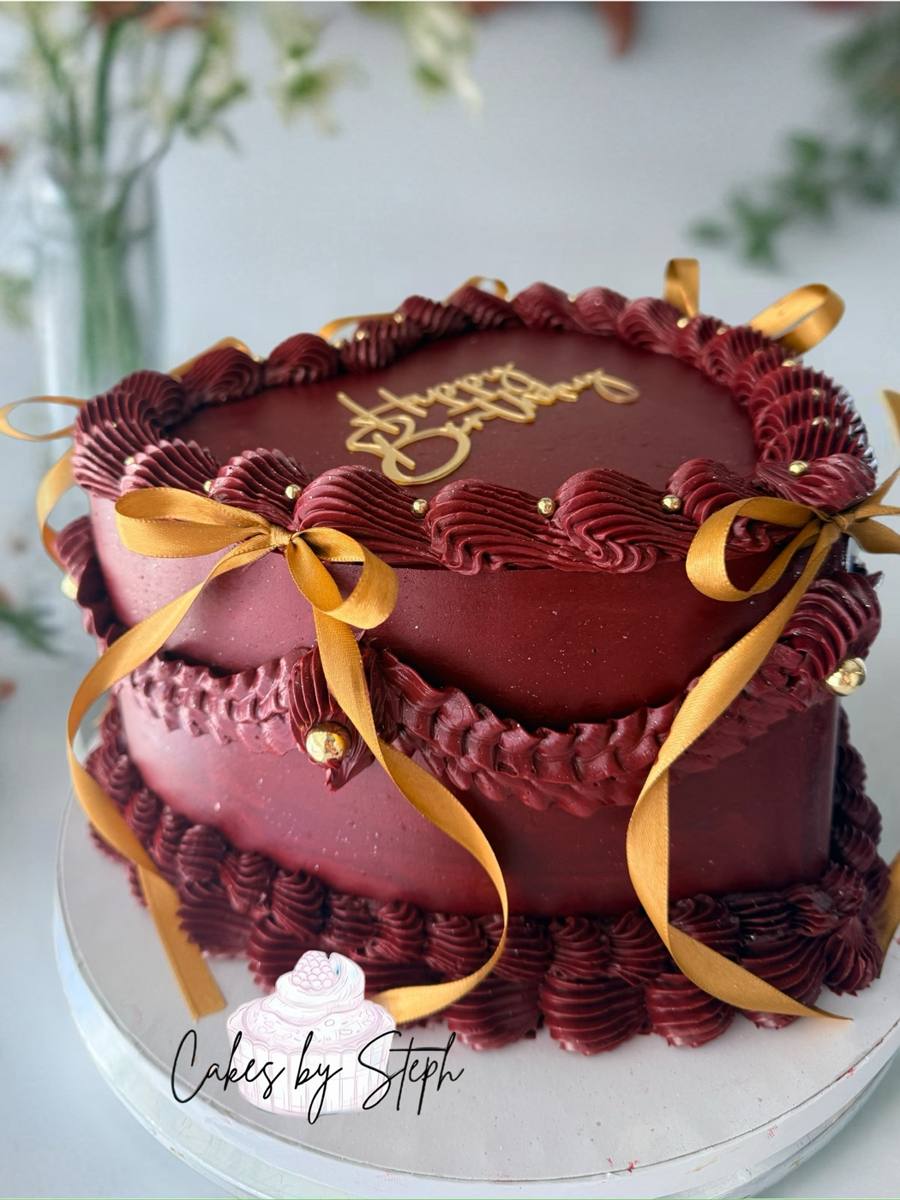 Deep burgundy buttercream cake with gold Happy Birthday topper and ribbon bows by Cakes by Steph, Leesburg VA