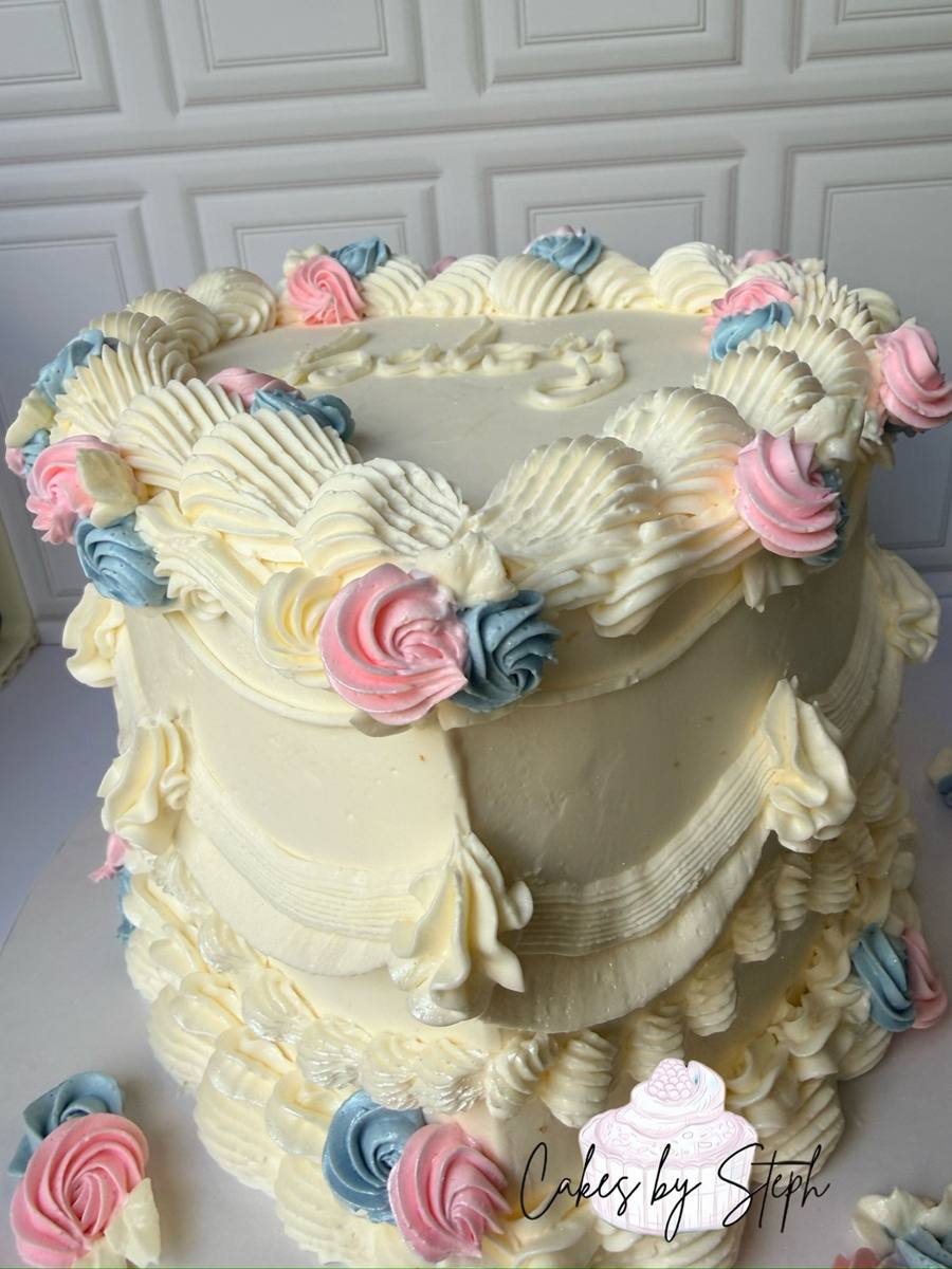 Heart-shaped cream cake with pink and blue rosettes by Cakes by Steph, Leesburg VA