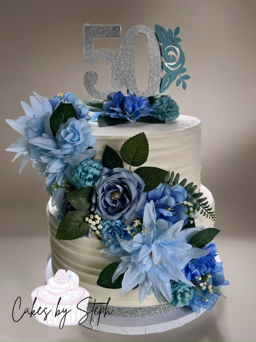 Two-tier white cake, blue florals, silver "50" topper by Cakes by Steph, Leesburg VA