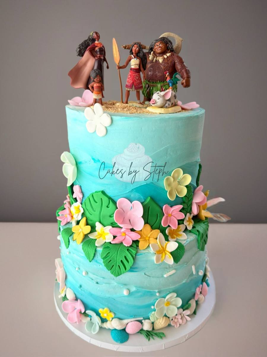 Two-tier blue ocean cake, Moana character toppers, tropical flowers by Cakes by Steph, Leesburg VA