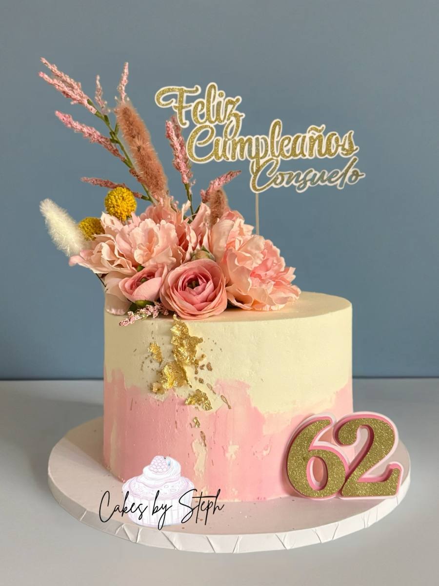 Pink cream cake, "Feliz Cumpleaños Consuelo", florals and gold "62" by Cakes by Steph, Leesburg VA