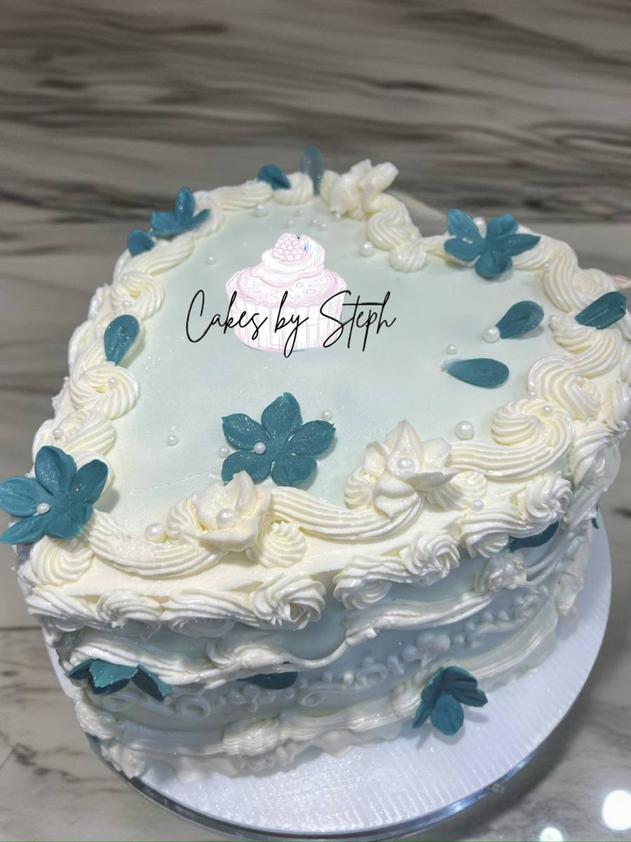 Heart-shaped white cake with blue sugar flowers and pearls by Cakes by Steph, Leesburg VA