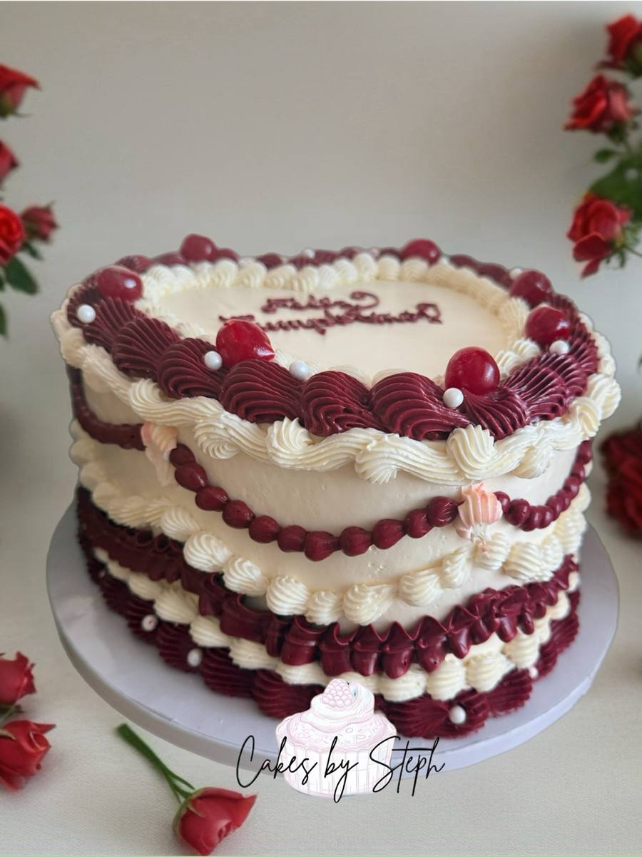 Heart-shaped burgundy cream vintage cake with Feliz Cumpleanos script by Cakes by Steph, Leesburg VA