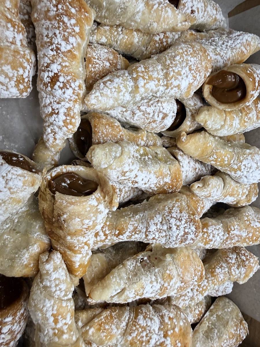 Cachitos peruanos rellenos de manjar blanco y espolvoreados con azúcar glas por Cakes by Steph
